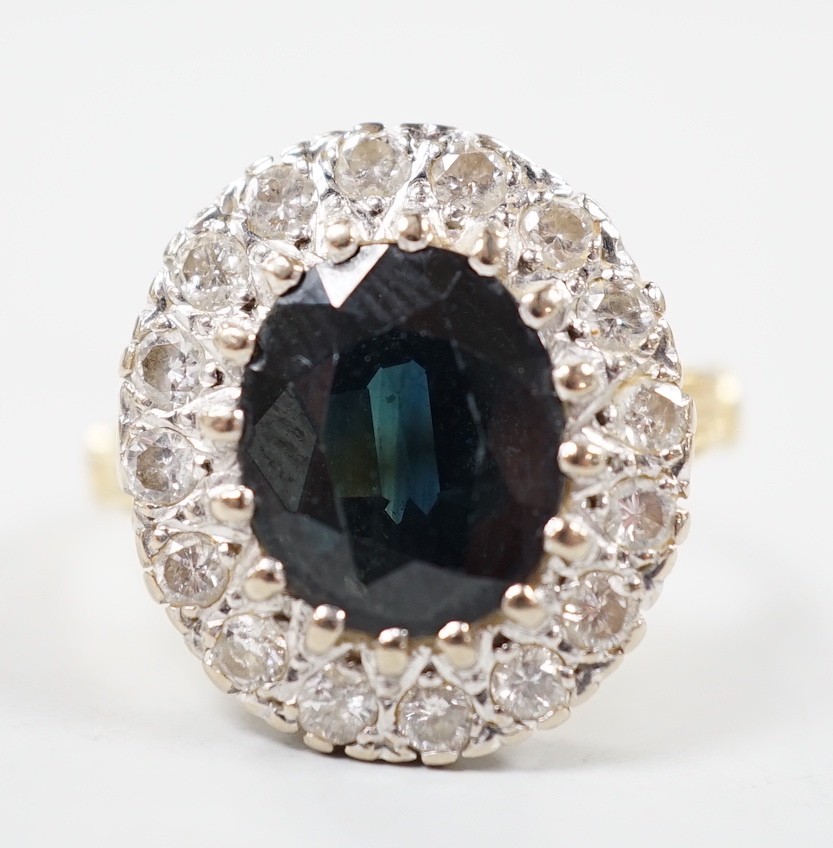 A 1970's? 18ct gold, single stone oval cut sapphire and illusion set diamond cluster ring, size O/P, gross weight 8.2 grams.